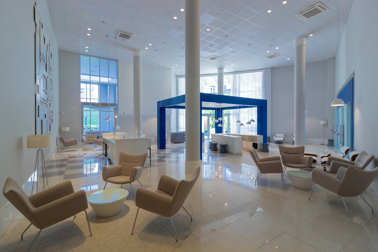 Moderne Bürolobby mit beigen Sesseln und einer blauen Struktur.